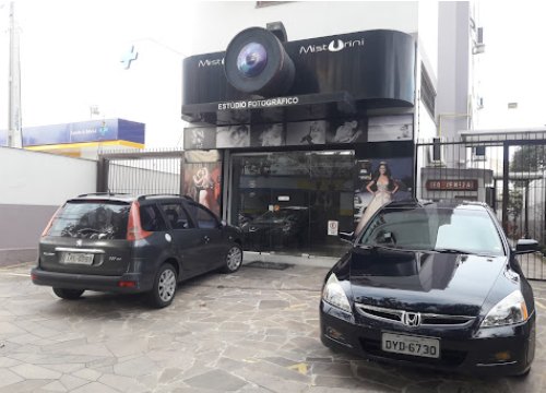 Fachada do Misturini Studio: letreiro preto em formato de câmera fotográfica sobre a entrada do prédio.